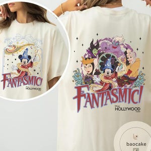 May include: Cream-colored t-shirt featuring a colorful graphic of Mickey Mouse in a wizard hat, with the text "Fantasmic! Hollywood" on the front. The back of the shirt displays Disney villains and the same text.