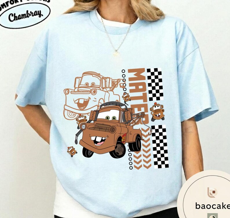 May include: Pale blue t-shirt with a brown cartoon tow truck design and the word "MATEr" in a vertical block. The design includes a checkered flag pattern and the text "Chambray" in a circular design.