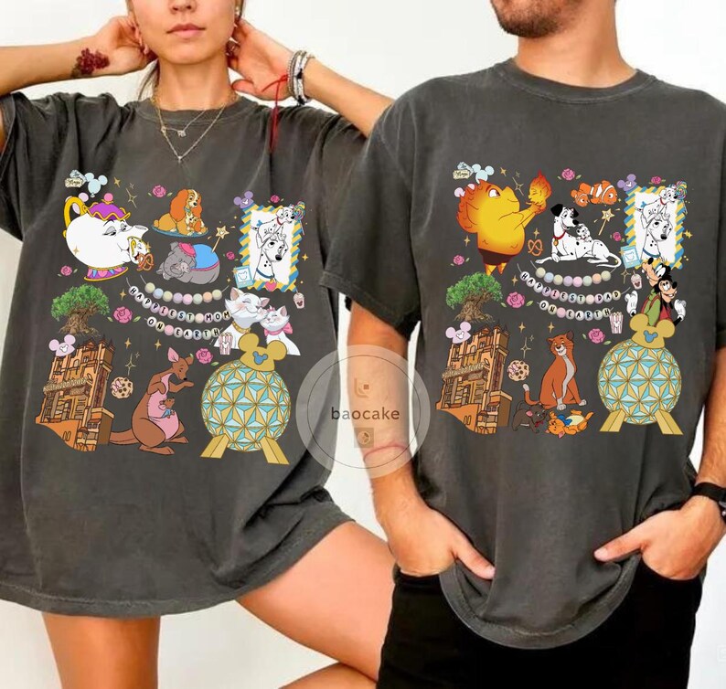 May include: Dark gray t-shirts with colorful cartoon character graphics. The designs include various characters and elements, such as a teapot, a kangaroo, and a building. The shirts are worn by two people.