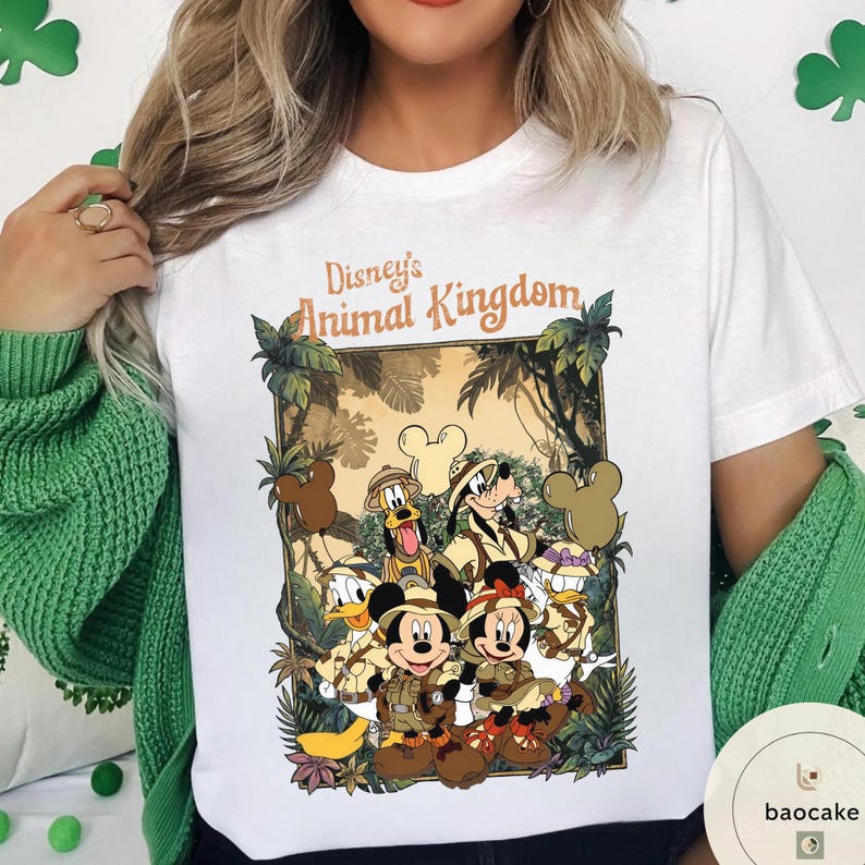 May include: White t-shirt featuring a colorful graphic of Disney's Animal Kingdom characters, including Mickey and Minnie Mouse, Donald Duck, and Goofy. The design is set against a jungle backdrop with the text "Disney's Animal Kingdom".