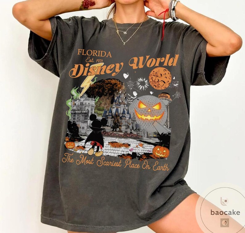 May include: Dark gray t-shirt with a Halloween-themed Disney World graphic. The design includes a castle, Mickey Mouse, pumpkins, and the text "Florida Disney World" and "The Most Scariest Place On Earth."