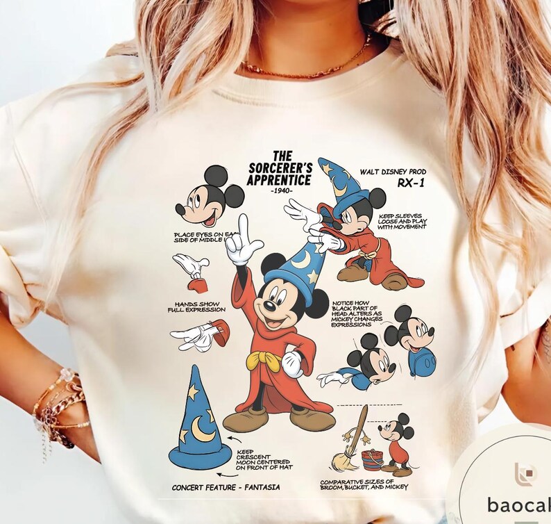 May include: Cream-colored t-shirt featuring a graphic of Mickey Mouse in his Sorcerer's Apprentice attire. The design includes illustrations and text detailing the character's features and the film's production notes. The text includes "The Sorcerer's Apprentice -1940-" and "Walt Disney Prod RX-1".