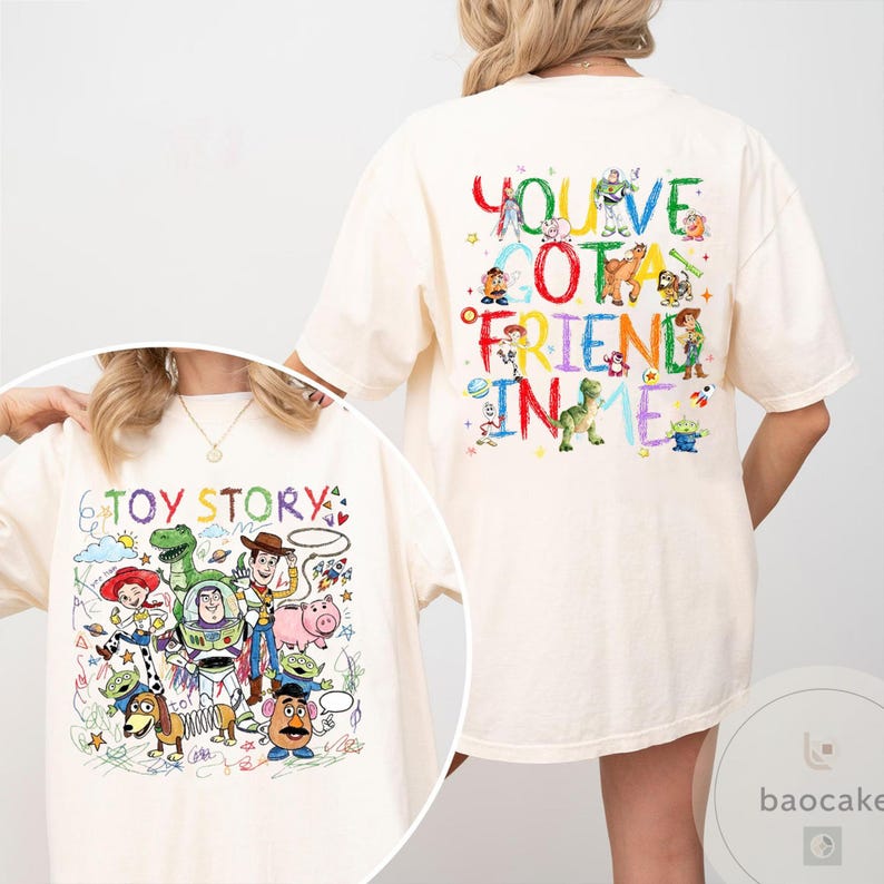 May include: Cream-colored t-shirt featuring colorful illustrations of characters from the animated film "Toy Story." The front of the shirt displays the text "Toy Story" with various characters. The back of the shirt has the phrase "You've Got a Friend in Me."
