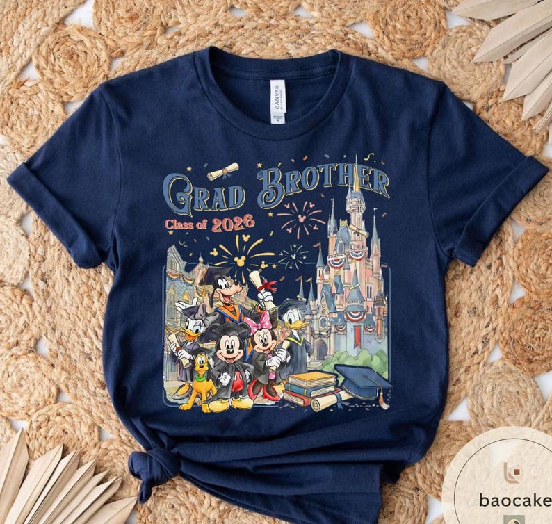 May include: Navy blue t-shirt with a colourful graphic featuring Disney characters, a castle, fireworks, and the text "Grad Brother Class of 2026". The design includes Mickey Mouse, Donald Duck, and Goofy.