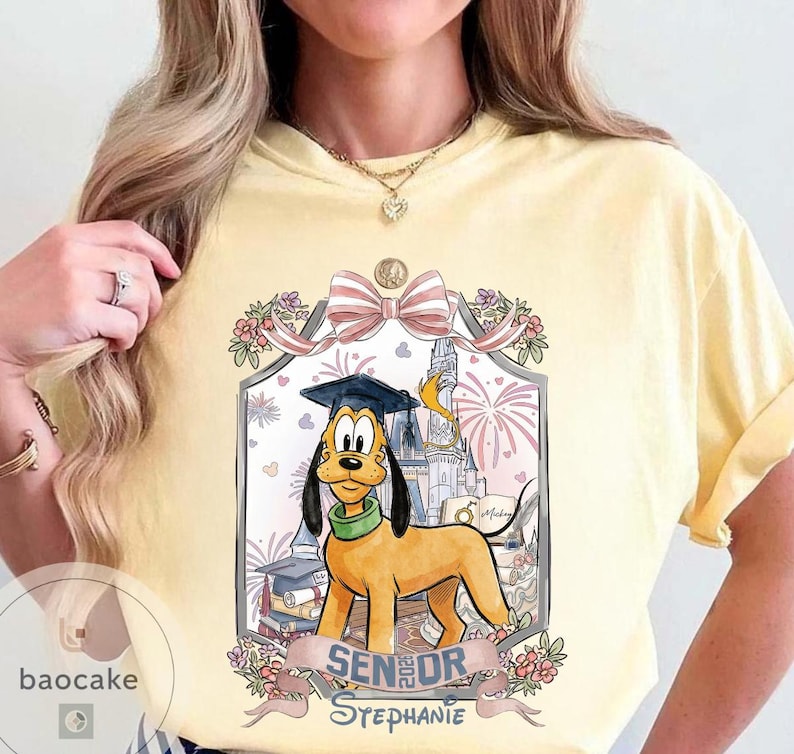 May include: Yellow t-shirt featuring a cartoon Pluto wearing a graduation cap, with the text "Senior Stephanie" and a Disney castle illustration. The design includes fireworks and floral accents.