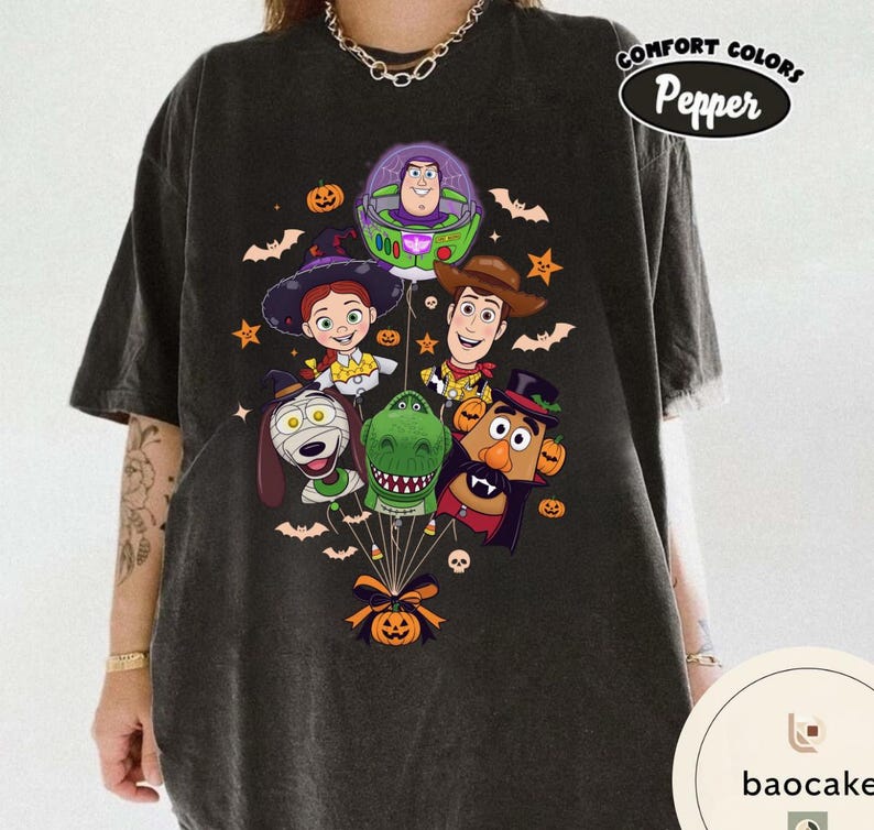 Pode incluir: Uma t-shirt cinzento-carv&atilde;o com uma impress&atilde;o gr&aacute;fica de personagens de Toy Story vestidos para o Halloween, incluindo Buzz Lightyear, Woody, Jessie, Rex, Slinky Dog e Mr. Potato Head, unidos por um la&ccedil;o e uma ab&oacute;bora de Halloween.
