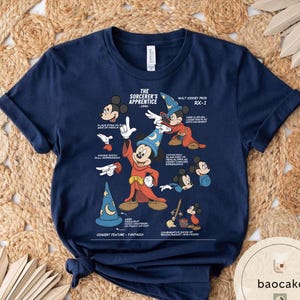 May include: Navy blue t-shirt featuring a graphic of Mickey Mouse as the Sorcerer's Apprentice from Fantasia. The design includes various poses and details from the film, with text that reads "The Sorcerer's Apprentice - 1940" and "Walt Disney Prod RX-1".