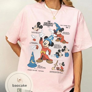 May include: Pink t-shirt featuring a graphic of Mickey Mouse in his Sorcerer's Apprentice outfit, with text and illustrations from the 1940 Fantasia film. The shirt includes the text "THE SORCERER'S APPRENTICE -1940-" and "WALT DISNEY PROD RX-1".