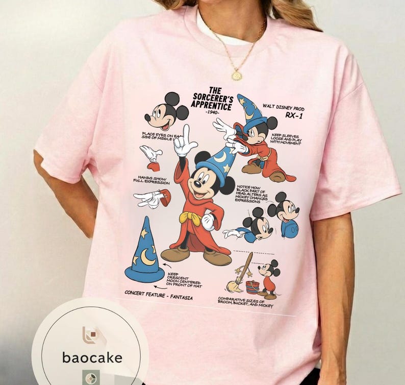 May include: Pink t-shirt featuring a graphic of Mickey Mouse in his Sorcerer's Apprentice outfit, with text and illustrations from the 1940 Fantasia film. The shirt includes the text "THE SORCERER'S APPRENTICE -1940-" and "WALT DISNEY PROD RX-1".