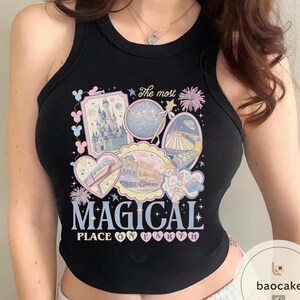 May include: Black tank top with a colourful graphic featuring theme park imagery, including a castle, Spaceship Earth, and a monorail. The text "The most MAGICAL PLACE ON EARTH" is displayed in a whimsical font.