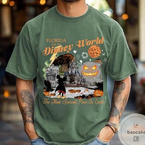 May include: Green t-shirt with a Halloween-themed Disney World graphic. The design includes a pumpkin, Mickey Mouse, and the text "Florida Disney World Est. 1971" and "The Most Scariest Place On Earth."
