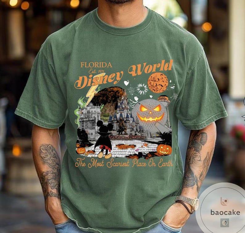 May include: Green t-shirt with a Halloween-themed Disney World graphic. The design includes a pumpkin, Mickey Mouse, and the text "Florida Disney World Est. 1971" and "The Most Scariest Place On Earth."