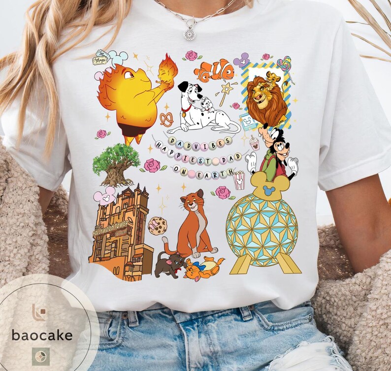 May include: White t-shirt featuring colorful cartoon characters and the text "Happiest Dad on Earth." The design includes images of a lion, Dalmatian dogs, Mickey Mouse, and other animated figures. The shirt has a crew neck and short sleeves.