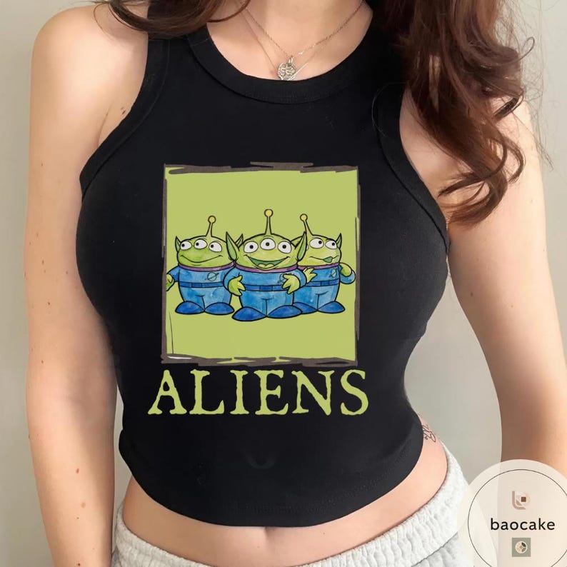 K&ouml;nnte beinhalten: Ein schwarzes &auml;rmelloses Tanktop mit einem Grafikdruck von drei gr&uuml;nen, drei&auml;ugigen Au&szlig;erirdischen in blauen Anz&uuml;gen innerhalb eines hellgr&uuml;nen Quadrats. Das Wort ALIENS ist in gro&szlig;en, hellgr&uuml;nen Gro&szlig;buchstaben unter der Grafik gedruckt.