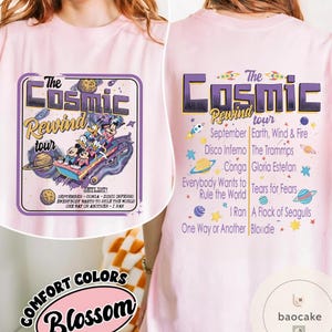 May include: Light pink t-shirt featuring a graphic of a space-themed tour with cartoon characters. The front design includes the text "The Cosmic Rewind Tour" and a setlist. The back of the shirt also has the tour name and a list of bands.
