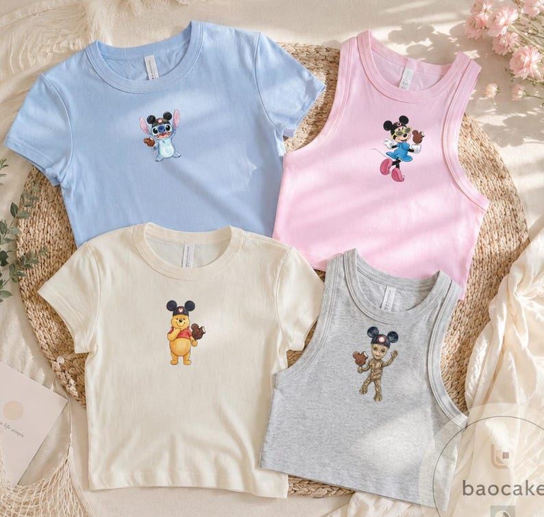 May include: A collection of four shirts featuring Disney character graphics. The set includes a light blue t-shirt with Stitch, a pink tank top with Minnie Mouse, a cream t-shirt with Winnie the Pooh, and a gray tank top with Groot, all wearing mouse ears.