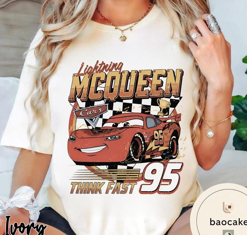 Puede incluir: Camiseta de color marfil con un gr&aacute;fico de Rayo McQueen de la pel&iacute;cula Cars. El dise&ntilde;o incluye el texto "Lightning McQueen", "Cars", "95" y "Think Fast". El coche de dibujos animados es rojo con detalles en negro y amarillo.
