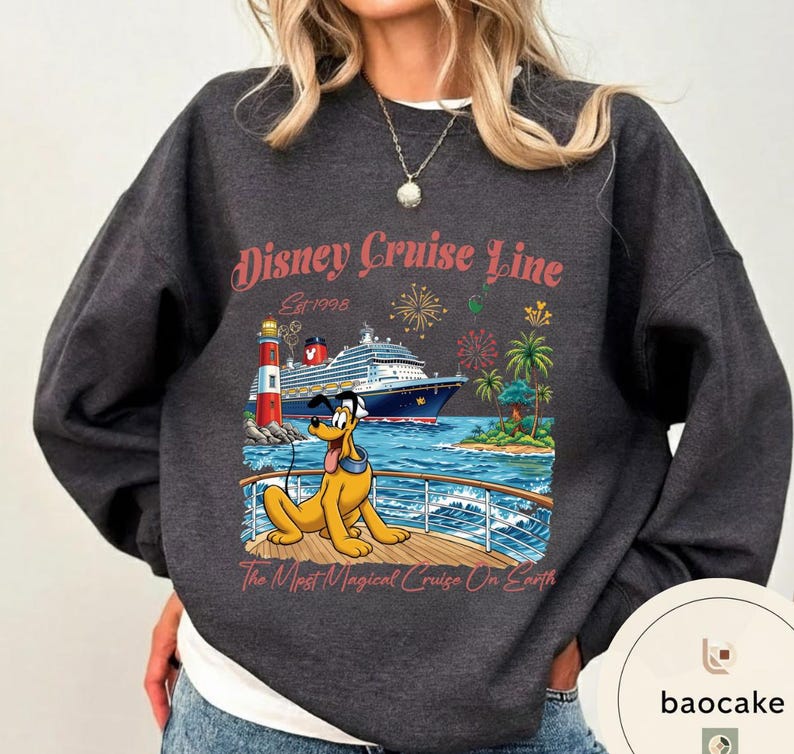 K&ouml;nnte beinhalten: Dunkelgraues Sweatshirt mit einem Disney Cruise Line-Motiv. Das Design zeigt ein Kreuzfahrtschiff, Pluto, einen Leuchtturm, Palmen und Feuerwerk. Der Text lautet "Disney Cruise Line Est. 1998" und "The Most Magical Cruise On Earth."