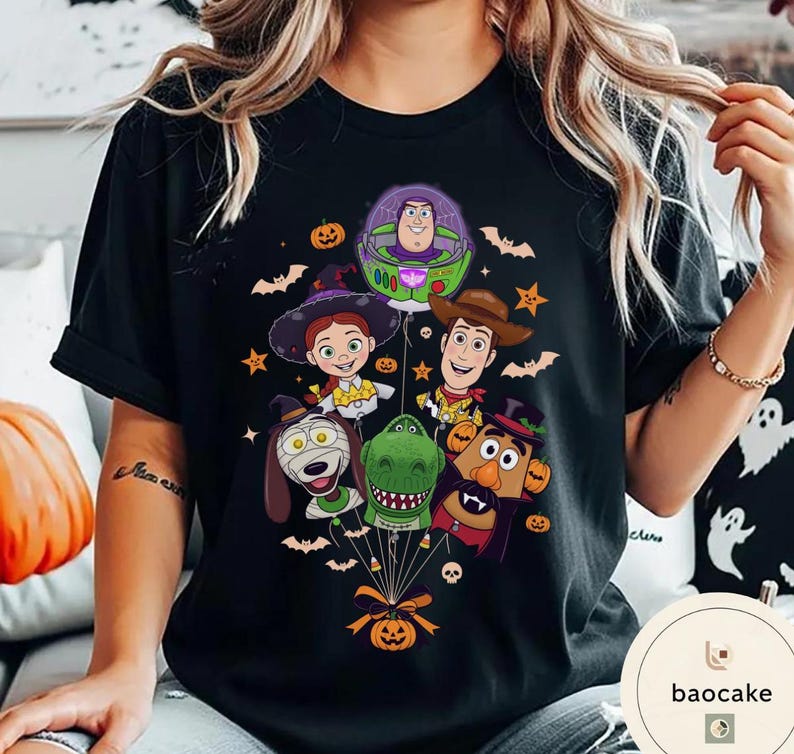 Pode incluir: Uma t-shirt preta com uma impress&atilde;o gr&aacute;fica de personagens de Toy Story vestidos para o Halloween. O design mostra Buzz Lightyear, Woody, Jessie, Rex, Slinky Dog e Mr. Potato Head como bal&otilde;es presos a uma ab&oacute;bora, rodeados por morcegos.