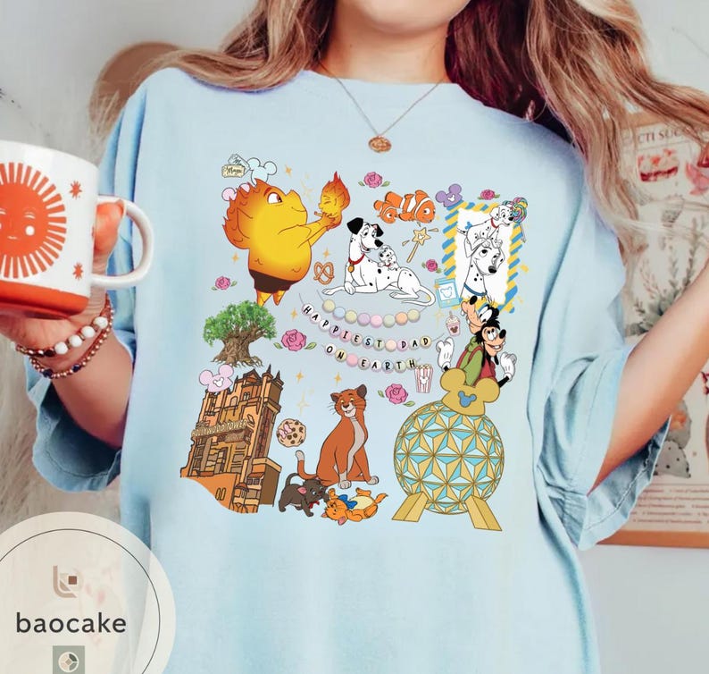 May include: Light blue t-shirt featuring a colorful graphic with cartoon characters, including Dalmatian dogs, Mickey Mouse, and a cat. The text "Happiest Dad on Earth" is also visible. A white mug with a sun design is held in the image.