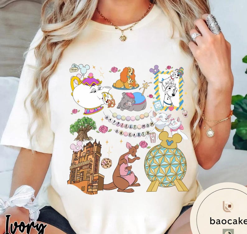 May include: Ivory-colored t-shirt featuring colorful cartoon illustrations of Disney characters and the text "Happiest Mom on Earth." The design includes a teapot, dogs, cats, a kangaroo, and a castle.