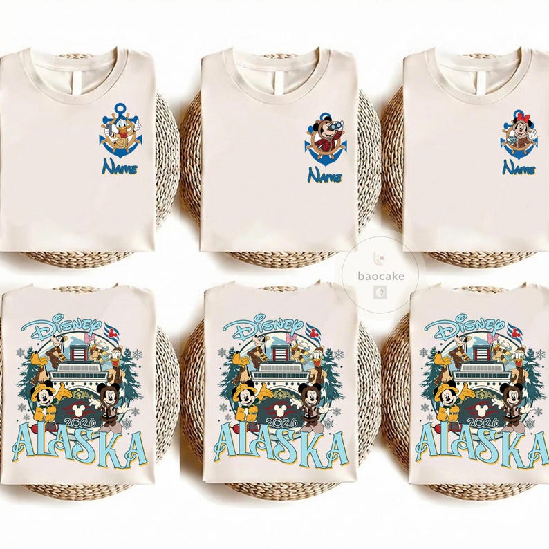 May include: Cream-colored t-shirts with Disney character designs. Some shirts feature an anchor with a character and the word "Name" in blue. Other shirts have a Disney Alaska 2024 design with Mickey and friends.