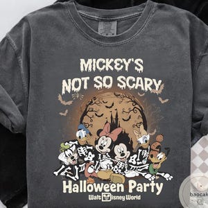 May include: Dark gray t-shirt featuring a Halloween design with Mickey Mouse and friends in skeleton costumes. The shirt includes the text "Mickey's Not So Scary Halloween Party" and "Walt Disney World".