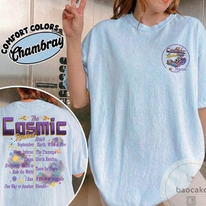 May include: Light blue t-shirt with "The Cosmic Rewind Tour" graphic on the back, featuring a list of bands and the text "September". The front has a smaller graphic and the word "Name". Made of Comfort Colors Chambray.