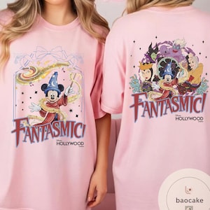 May include: Pink t-shirts featuring the word "Fantasmic!" in a stylized font. One shirt displays Mickey Mouse in a sorcerer's outfit, while the other showcases Disney villains. The shirts also include "Hollywood" text.