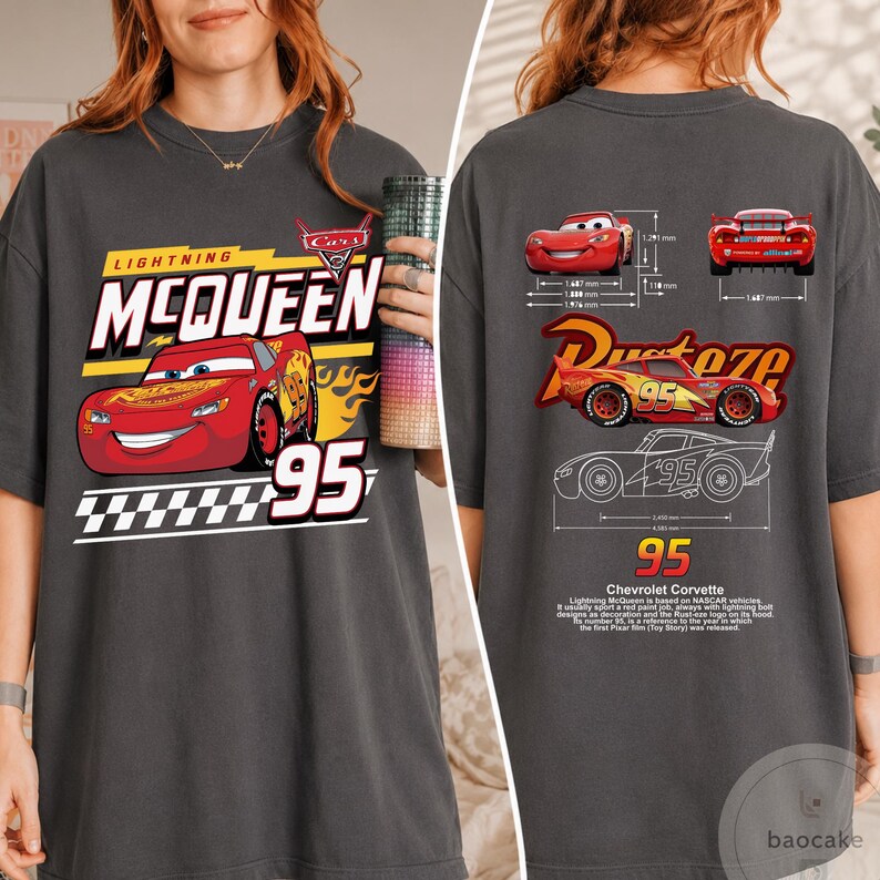 May include: A charcoal grey t-shirt featuring a graphic of Lightning McQueen on the front with the text "Lightning McQueen 95". The back displays technical diagrams of the car, the "Rust-eze" logo, and text detailing the character's design history.