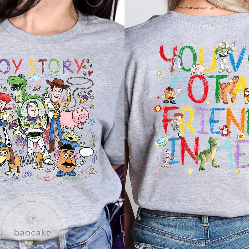 May include: A light gray t-shirt featuring colorful illustrations of characters from the animated film "Toy Story." The front of the shirt displays the words "Toy Story" and various characters. The back of the shirt says "You've Got a Friend in Me."