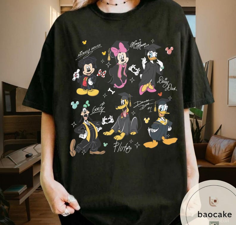 May include: Black t-shirt featuring a graphic of Mickey Mouse, Minnie Mouse, Donald Duck, Daisy Duck, Goofy, and Pluto in graduation attire. The design includes the characters' names and graduation year. The shirt has a crew neck and short sleeves.