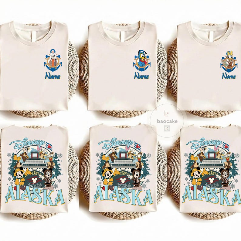 May include: Cream-colored t-shirts with Disney character designs. Some shirts feature an anchor with a character and the word "Name" in blue. Other shirts have a Disney Alaska 2024 design with Mickey and friends.