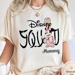 Puede incluir: Camiseta color crema con el texto "Disney You" en escritura negra, y un gr&aacute;fico de Minnie Mouse con un kimono rosa. Un globo colorido est&aacute; sobre la cabeza de Minnie, y la palabra "Mommy" est&aacute; debajo.