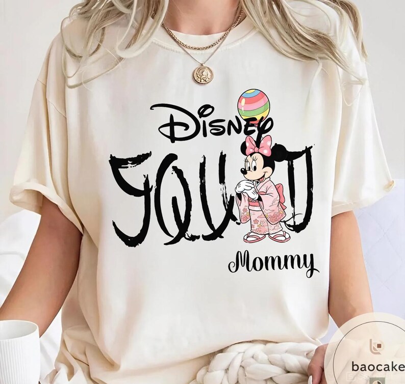 Puede incluir: Camiseta color crema con el texto "Disney You" en escritura negra, y un gr&aacute;fico de Minnie Mouse con un kimono rosa. Un globo colorido est&aacute; sobre la cabeza de Minnie, y la palabra "Mommy" est&aacute; debajo.