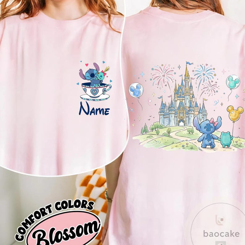 May include: A light pink t-shirt featuring a cartoon illustration of Stitch. The front of the shirt has Stitch in a teacup with the word "Name" below. The back of the shirt shows a castle, fireworks, and Stitch with a frog and balloons.