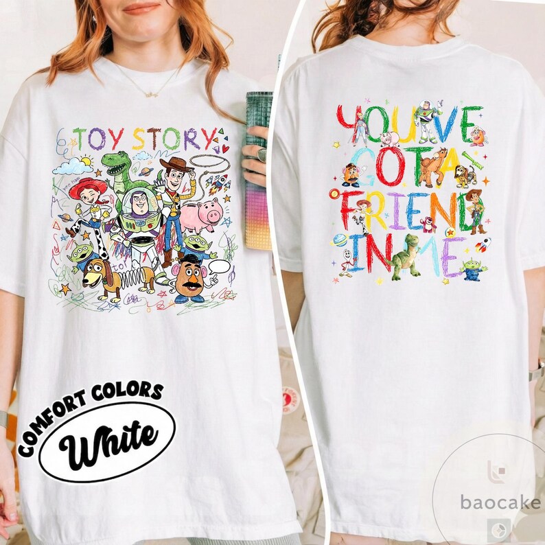 May include: White t-shirt featuring colorful illustrations of Toy Story characters on the front and back. The front design includes the text "TOY STORY" and the back says "YOU'VE GOT A FRIEND IN ME". The shirt also has the text "COMFORT COLORS White".