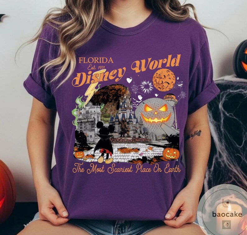 May include: Purple t-shirt with a Halloween-themed Disney World graphic. The design includes a jack-o'-lantern, Mickey Mouse, and the text "Florida Disney World Est. 1971" and "The Most Scariest Place On Earth."