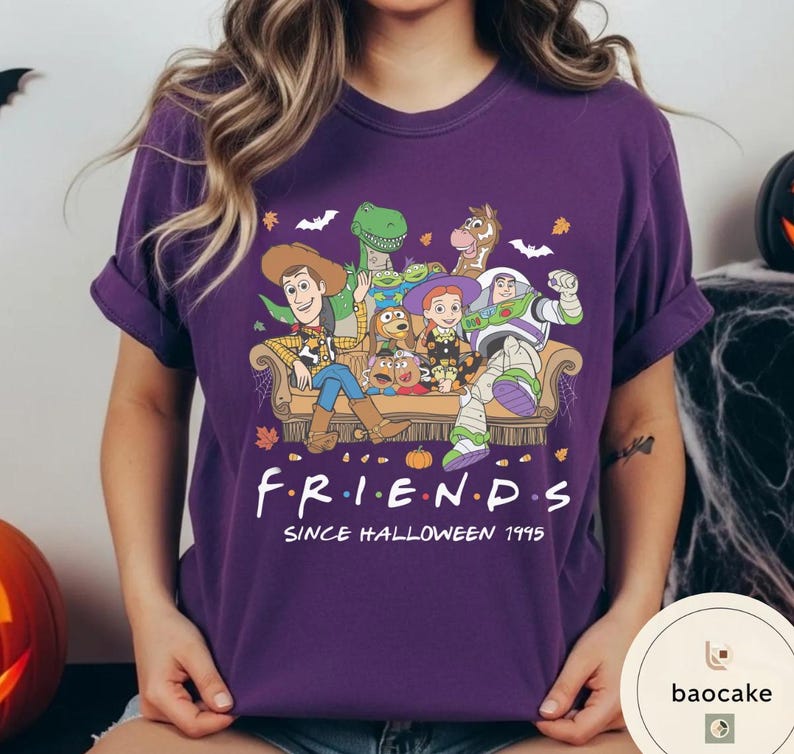 May include: A purple t-shirt featuring a graphic of Toy Story characters sitting on a couch with the text "F.R.I.E.N.D.S SINCE HALLOWEEN 1995". The design includes Woody, Buzz Lightyear, Jessie, Rex, Slinky Dog, Mr. Potato Head, and Bullseye.