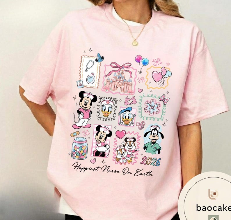 May include: Pink t-shirt featuring cartoon characters and medical-themed illustrations. The shirt includes images of Mickey and Minnie Mouse, Donald Duck, and Goofy in nurse attire, along with a castle, balloons, and the text "Happiest Nurse On Earth" and the year "2026".