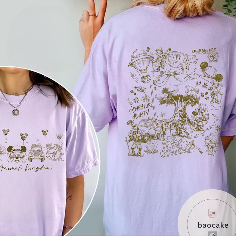 May include: A light purple t-shirt featuring a detailed graphic design. The front of the shirt says "Animal Kingdom" with Mickey Mouse and other park-themed icons. The back of the shirt has a map-like design with the words "Adventure Awaits!" and "Kilimanjaro".