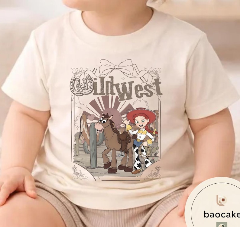 Pu&ograve; includere: T-shirt beige con un'illustrazione a cartoni animati di un cavallo, una cowgirl e la scritta "Wild West". Il disegno &egrave; ambientato su uno sfondo desertico. La maglietta &egrave; realizzata in tessuto morbido e chiaro.