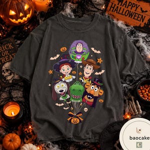Pode incluir: Uma t-shirt cinzento-carv&atilde;o com uma impress&atilde;o gr&aacute;fica de personagens de Toy Story vestidos para o Halloween, incluindo Buzz Lightyear, Woody, Jessie, Rex, Slinky Dog e o Sr. Batata, todos ligados por fios a uma ab&oacute;bora.