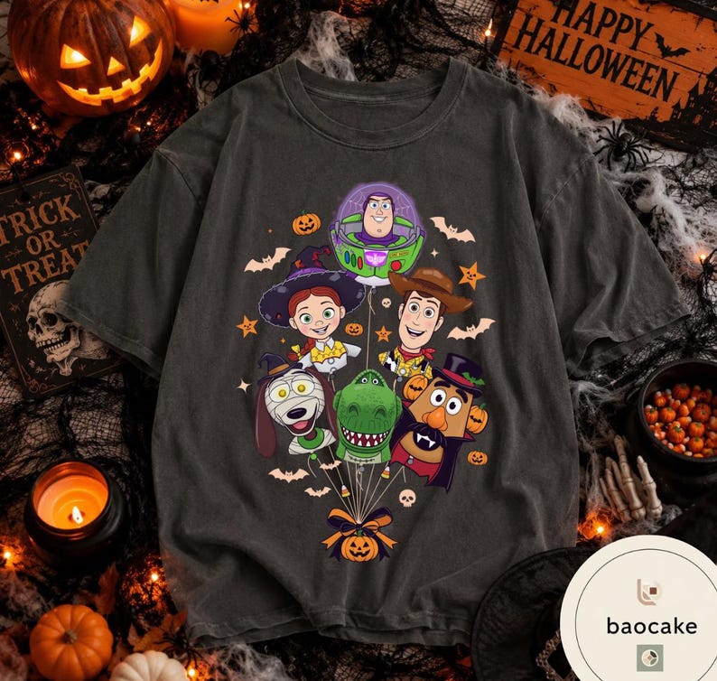 Pode incluir: Uma t-shirt cinzento-carv&atilde;o com uma impress&atilde;o gr&aacute;fica de personagens de Toy Story vestidos para o Halloween, incluindo Buzz Lightyear, Woody, Jessie, Rex, Slinky Dog e o Sr. Batata, todos ligados por fios a uma ab&oacute;bora.