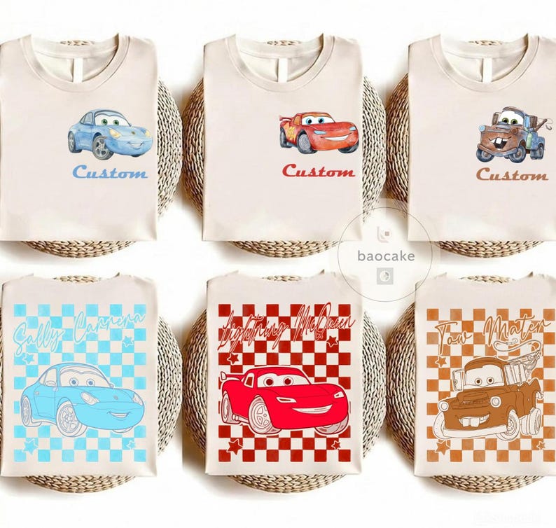May include: Six beige t-shirts with cartoon car graphics. The shirts feature characters like Lightning McQueen, Sally Carrera, and Tow Mater. Each shirt has the word "Custom" or a character's name. The designs are in blue, red, and brown.