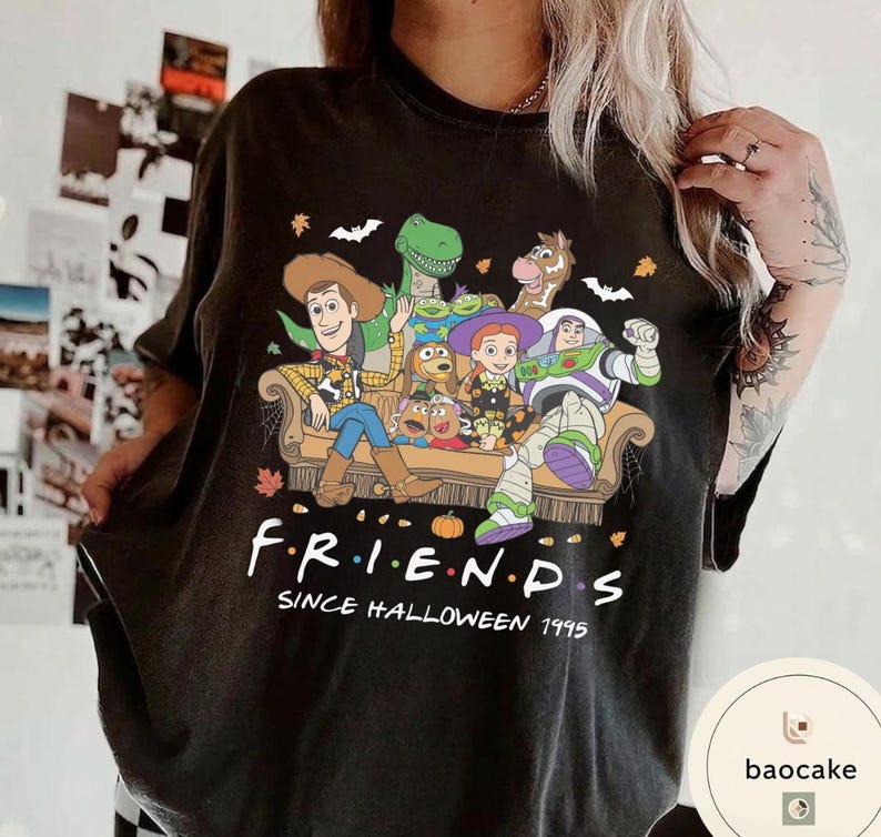 May include: A black t-shirt featuring a graphic of Toy Story characters sitting on a couch. The text reads F R I E N D S SINCE HALLOWEEN 1995. The design includes Woody, Buzz Lightyear, Jessie, Rex, Bullseye, and Mr. Potato Head with autumn leaves.
