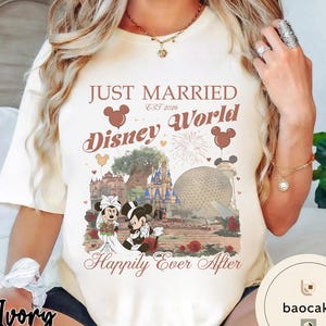 May include: Ivory-colored t-shirt with a Disney World wedding theme. The shirt features the text "Just Married Disney World Est 2026" with Mickey and Minnie Mouse in wedding attire, and the phrase "Happily Ever After."