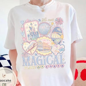May include: White t-shirt with a colourful graphic featuring theme park icons, including a castle, a sphere, and a monorail. The text "The most MAGICAL PLACE ON EARTH" is displayed in a playful font.