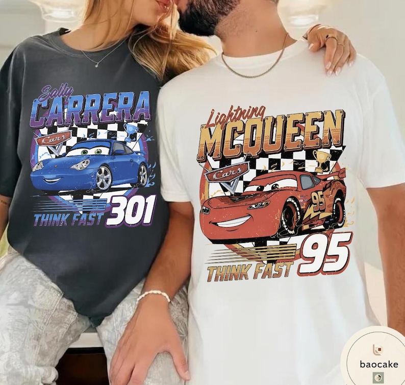 Puede incluir: Dos camisetas con gr&aacute;ficos de coches. Una es gris oscuro con un coche azul y el texto "Sally Carrera" y "Think Fast 301". La otra es blanca con un coche rojo y el texto "Lightning McQueen" y "Think Fast 95".