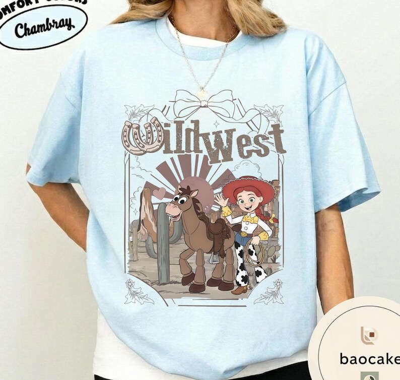 Pu&ograve; includere: T-shirt azzurra con grafica Wild West. La grafica include una cowgirl dei cartoni animati, un cavallo e la scritta "Wild West". Il design incorpora un ferro di cavallo ed elementi del paesaggio desertico. La maglietta ha scollo tondo e maniche corte.